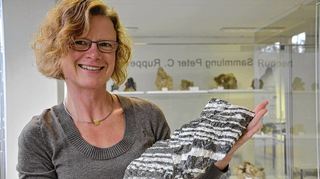 <p>Dorothée Kleinschrot hält einen Bändererz aus der Sammlung Ruppert in ihren Händen.</p>