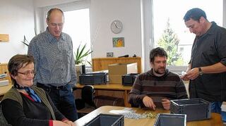 <p>Die beiden Geschäftsführer der VOP Alfred Wolfert (stehend links) und Jürgen Groß (stehend rechts) schauen den VOP-Tagesstätten-Besuchern bei der Arbeit über die Schulter.</p>