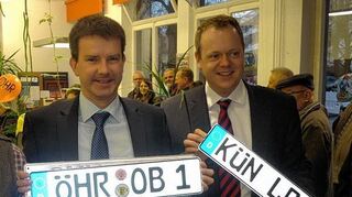 <p>OB Thilo Michler (links) mit seinem neuen Kennzeichen ÖHR OB 1 und Landrat Dr. Matthias Neth (rechts), der weiterhin sein Kennzeichen KÜN LR 1 behält.</p>